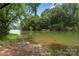 Scenic lake view with a small dock and vibrant greenery, offering a tranquil natural setting at 12726 Rusty Blackbird Way, Charlotte, NC 28278