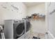 Functional laundry room with modern washer and dryer units and ample storage space at 12726 Rusty Blackbird Way, Charlotte, NC 28278