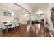 Open-concept living space with hardwood floors, a fireplace, and coffered ceilings, connecting dining and seating areas at 12726 Rusty Blackbird Way, Charlotte, NC 28278