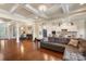 Open-concept living space with hardwood floors, a fireplace, and coffered ceilings, connecting dining room and kitchen at 12726 Rusty Blackbird Way, Charlotte, NC 28278