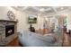 Open-concept living room with a stone fireplace, coffered ceiling, hardwood floors, and neutral paint at 12726 Rusty Blackbird Way, Charlotte, NC 28278