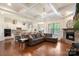 Open-concept living space with hardwood floors, a fireplace, and coffered ceilings, connecting the kitchen and seating areas at 12726 Rusty Blackbird Way, Charlotte, NC 28278