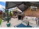 This patio showcases a cozy seating area with a ceiling fan, complemented by a grill and a nearby staircase at 12726 Rusty Blackbird Way, Charlotte, NC 28278