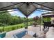 The outdoor patio features a seating area, grill, and a view of the lush green landscape with a pond at 12726 Rusty Blackbird Way, Charlotte, NC 28278