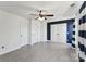 Bedroom with fan, two closets, white doors, a navy accent wall and striped curtains at 12727 Bullock Greenway Blvd, Charlotte, NC 28277