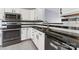 Updated kitchen with black countertops, stainless steel appliances and fixtures, and white cabinets at 12727 Bullock Greenway Blvd, Charlotte, NC 28277