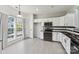 Bright kitchen featuring white cabinets, black countertops, and stainless steel appliances with large window at 12727 Bullock Greenway Blvd, Charlotte, NC 28277