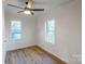 Well-lit bedroom with ceiling fan, hardwood flooring, and two windows offering outdoor views at 1605 5Th St, Statesville, NC 28625