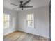 Bright bedroom with ceiling fan, hardwood flooring, and two windows offering outdoor views at 1605 5Th St, Statesville, NC 28625