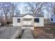 Charming single-story home with a gray metal roof, inviting front porch, and manicured landscaping at 1605 5Th St, Statesville, NC 28625