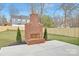 Spacious backyard featuring a custom brick fireplace, a concrete patio, and manicured lawn at 1817 S Mint St, Charlotte, NC 28203