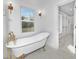 Elegant bathroom showcasing a freestanding tub with gold fixtures and a large window at 1817 S Mint St, Charlotte, NC 28203