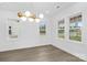 Well-lit dining room featuring a modern chandelier and large windows overlooking the front yard at 1817 S Mint St, Charlotte, NC 28203