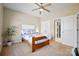 Bedroom with a ceiling fan, wood frame bed, beige walls, and an attached bathroom through an open door at 2205 Meleto Dr, Waxhaw, NC 28173