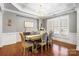 Formal dining room with modern chandelier, shutters, and hardwood floors at 2205 Meleto Dr, Waxhaw, NC 28173