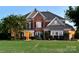 Charming two-story brick home with lush lawn and manicured landscaping at twilight at 2205 Meleto Dr, Waxhaw, NC 28173