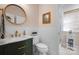 Stylish powder room featuring a round mirror, marble countertop, gold faucet, and tiled walls at 2205 Meleto Dr, Waxhaw, NC 28173