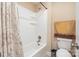 Standard bathtub and shower combination with white tile, accented with floral shower curtain and matching accessories at 2605 Lakefront Dr, Belmont, NC 28012