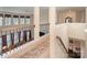 A sunlit upstairs hallway with carpet, railing, and view of the living room below at 2605 Lakefront Dr, Belmont, NC 28012