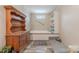 Bathroom with a cabinet with shelves, wood-look flooring, and a soaking tub at 2647 Dusty Trail Ln, Lancaster, SC 29720