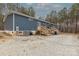 Home exterior shows blue siding and gravel yard and back porch with stairs at 2647 Dusty Trail Ln, Lancaster, SC 29720