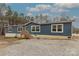 Inviting single-story home with blue siding, a wooden porch, and large windows at 2647 Dusty Trail Ln, Lancaster, SC 29720