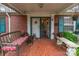 Inviting front porch with seating, red tile flooring and classic brick columns at 3021 Whitson Rd, Gastonia, NC 28054