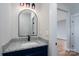 Bathroom showcasing a navy vanity cabinet with black hardware, granite countertop, and an arched mirror at 320 Cabarrus W Ave, Concord, NC 28025