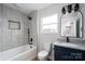 Modern bathroom with gray tiled walls, a bathtub, and stylish vanity with granite top at 320 Cabarrus W Ave, Concord, NC 28025