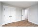 Bedroom featuring wood-look flooring, double door closet, base trim, and neutral paint at 320 Cabarrus W Ave, Concord, NC 28025