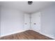 Bedroom featuring wood-look flooring, double door closet, base trim, and neutral paint at 320 Cabarrus W Ave, Concord, NC 28025