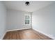 Small bedroom with wood-look flooring, base trim, one window, and neutral paint at 320 Cabarrus W Ave, Concord, NC 28025