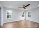 Spacious bedroom features wood-look flooring, base trim, neutral paint, ceiling fan, and three windows at 320 Cabarrus W Ave, Concord, NC 28025