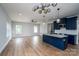 Open-concept kitchen and living area with modern lighting and hardwood floors at 320 Cabarrus W Ave, Concord, NC 28025