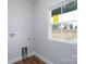 Laundry room featuring wood-look flooring, base trim, neutral paint, hookups, and a window at 320 Cabarrus W Ave, Concord, NC 28025