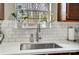 Close up of the kitchen sink with subway tile backsplash, faucet, and a view from the window at 3224 Heathstead Pl, Charlotte, NC 28210