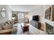 Cozy living room featuring a comfortable sofa, decorative fireplace, and a large window for natural light at 3224 Heathstead Pl, Charlotte, NC 28210