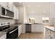 Modern kitchen with stainless steel appliances, granite countertops, white cabinets and light wood floors at 3516 Narrow Ln, Charlotte, NC 28215