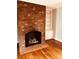 Close-up of brick fireplace with tiled hearth and built-in shelving at 3580 5Th Ne St, Hickory, NC 28601