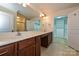 Bright bathroom with double sinks, white countertops, tiled floor, and walk-in closet at 4709 Polo Gate Blvd, Charlotte, NC 28216