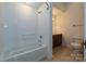 Well-lit bathroom features a tiled tub with shower, vanity with sink and toilet at 4709 Polo Gate Blvd, Charlotte, NC 28216