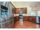 Well-lit kitchen featuring stainless steel appliances, granite countertops, and dark wood cabinets and hardwood floors at 4709 Polo Gate Blvd, Charlotte, NC 28216