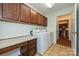 Laundry room with a desk, wooden cabinets, and tile floor with easy access to kitchen at 4709 Polo Gate Blvd, Charlotte, NC 28216