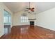 A spacious living room featuring hardwood floors, a fireplace, and a ceiling fan at 4709 Polo Gate Blvd, Charlotte, NC 28216