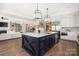 Open concept kitchen with large island, white cabinets, stainless steel appliances, and hardwood floors at 5608 Closeburn Rd, Charlotte, NC 28210