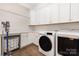 Bright laundry room features white cabinets, modern washer and dryer, and wooden floors at 5608 Closeburn Rd, Charlotte, NC 28210