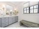 Well-lit bathroom featuring a vanity with double sinks, gray cabinets, and a large window at 5608 Closeburn Rd, Charlotte, NC 28210