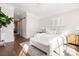 Bright main bedroom with white bedding, a ceiling fan, and access to a hallway with a sliding barn door at 5608 Closeburn Rd, Charlotte, NC 28210