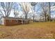 Spacious backyard view with a brick home, large trees, and lawn at 571 Amity Se Ave, Concord, NC 28025