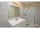 Bathroom featuring a single sink vanity with mirror and a glass-enclosed shower at 571 Amity Se Ave, Concord, NC 28025